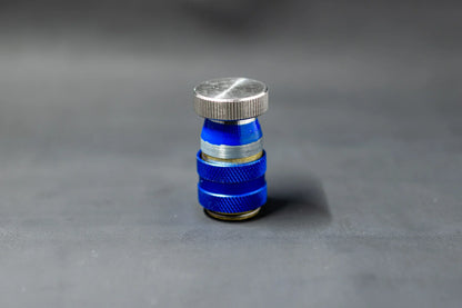 Blue car AC service valve leak repair cap on grey background
